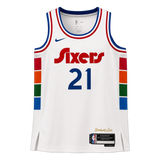 A white Philadelphia 76ers basketball jersey with blue, red, and orange accents, featuring the number 21 on the front. The jersey includes a Nike swoosh on the right chest, a team logo on the left chest, and a 'Brotherly Love' signature near the bottom hem.