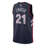 Back view of a dark navy blue basketball jersey with 'EMBIID' and the number '21' in white outlined with red, featuring the NBA logo at the collar.